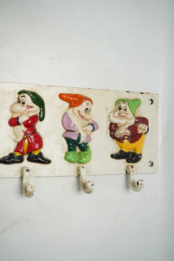 A 'Seven dwarfs' painted cast iron coat rack, 58cm wide. Condition - fair, some chipping